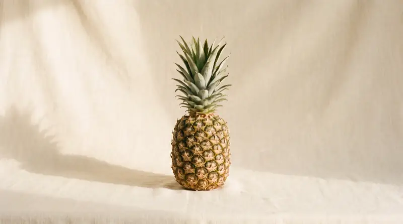 Sade krem fon önünde ananas; bebeğin bu haftaki yaklaşık boyutu.
